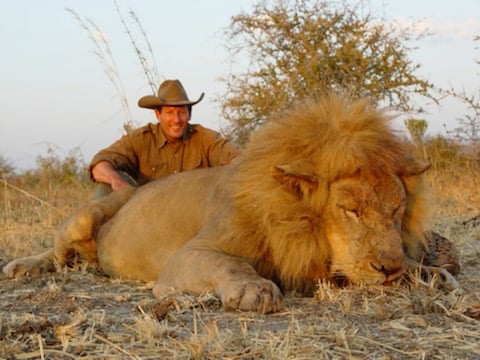 Chris Rudd Kneeling Next To A Lion